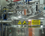 Reactor químico de metal con pegatinas de alerta.